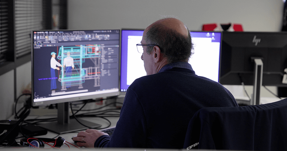 a man with glasses working on intralogistic on a computer